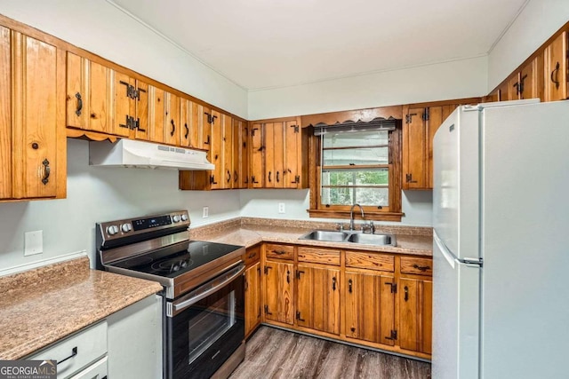 1105 S Parkwood Dr, Forest Park, GA 30297 - kitchen with freestanding refrigerator, stainless steel range with electric stovetop, under cabinet range hood, brown cabinets, and a sink