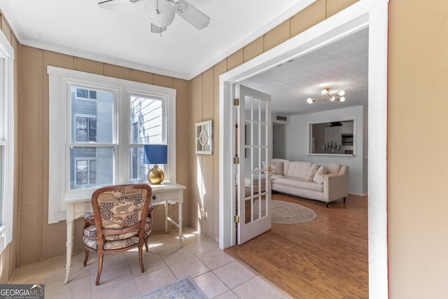 interior space with tile patterned floors and ceiling fan with notable chandelier