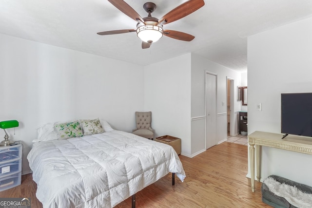 bedroom with baseboards, light wood-type flooring, and a ceiling fan