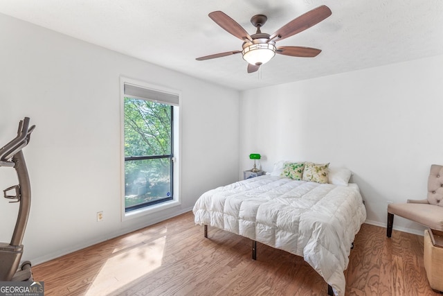 bedroom featuring baseboards, a ceiling fan, and wood finished floors