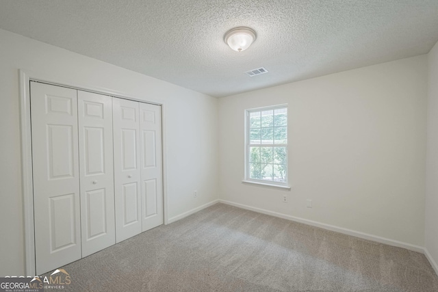 460 Mckneely Rd, Griffin, GA 30224 - unfurnished bedroom featuring a textured ceiling, carpet flooring, baseboards, and visible vents