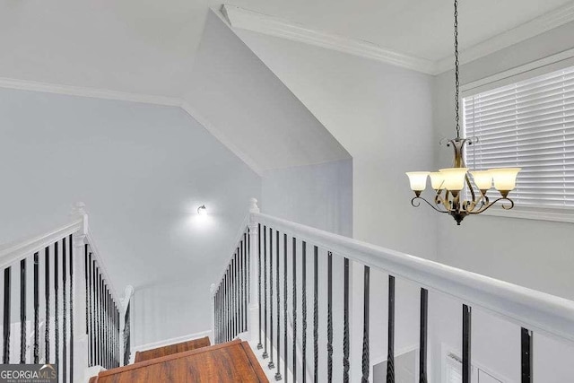 stairway with ornamental molding, a chandelier, and wood finished floors