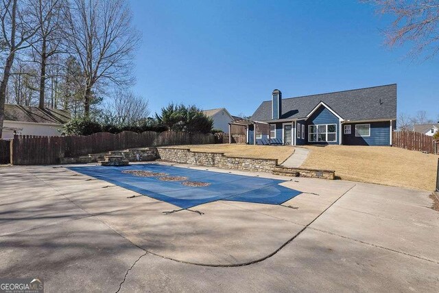 view of pool featuring a patio, a yard, a fenced in pool, and fence