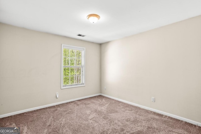 carpeted empty room featuring visible vents and baseboards