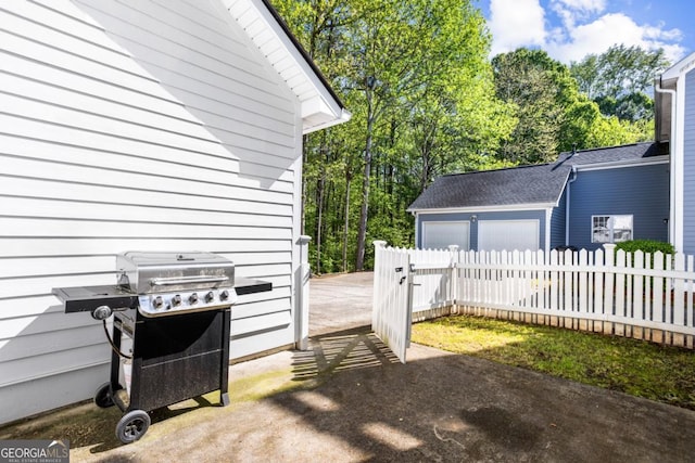 view of side of home featuring fence, a garage, and driveway