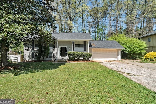 view of front facade with a garage, concrete driveway, fence, and a front lawn