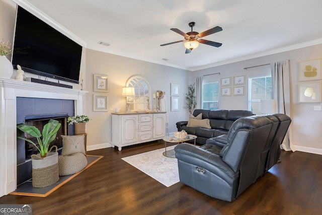 living room with visible vents, wood finished floors, crown molding, and ceiling fan