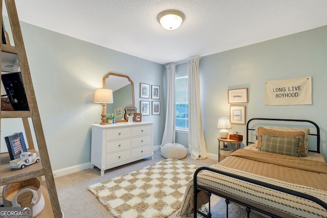 bedroom with light colored carpet, baseboards, and a textured ceiling