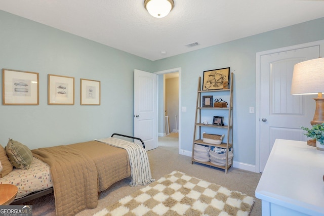 bedroom featuring visible vents, baseboards, and light carpet