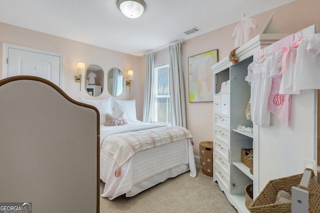 bedroom with visible vents and light carpet