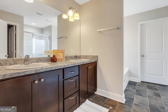 bathroom featuring a stall shower, double vanity, a sink, and visible vents