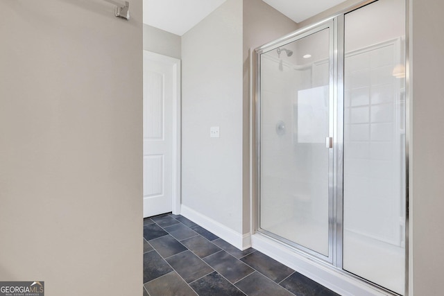 bathroom with a shower stall and baseboards