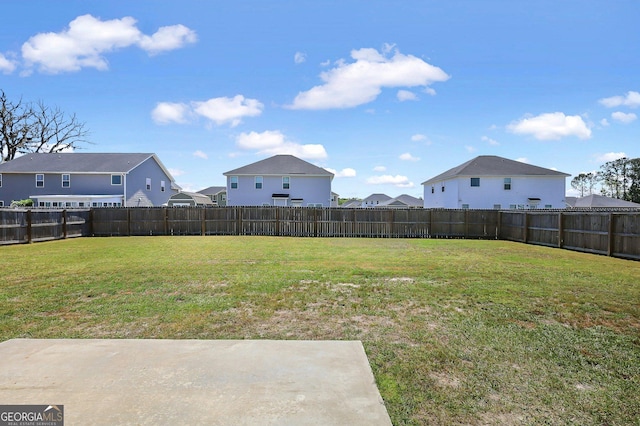 view of yard featuring a fenced backyard and a residential view