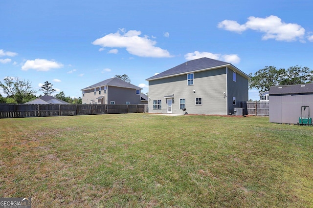 back of property with a yard, central AC unit, and a fenced backyard