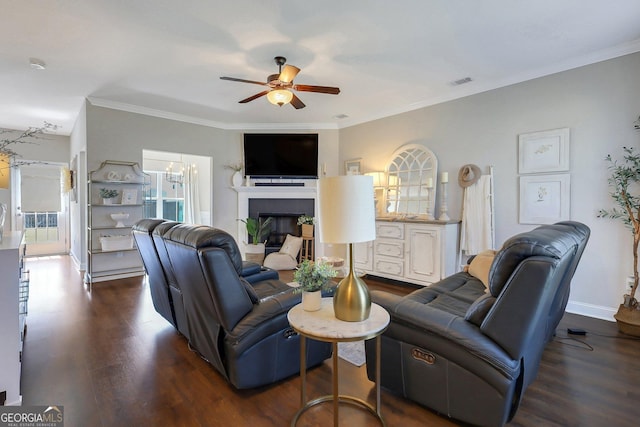 living area with visible vents, a fireplace, wood finished floors, and ceiling fan with notable chandelier