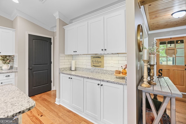 75 Flagstone Dr, Newnan, GA 30263 - kitchen with ornamental molding, white cabinetry, light wood-type flooring, tasteful backsplash, and light stone counters