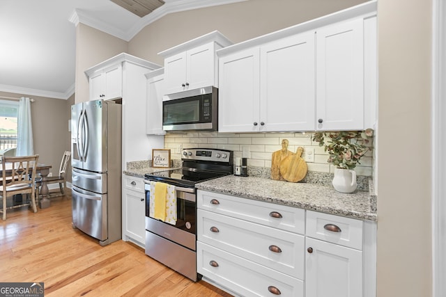 75 Flagstone Dr, Newnan, GA 30263 - kitchen featuring stainless steel appliances, ornamental molding, tasteful backsplash, white cabinets, and light wood-style floors