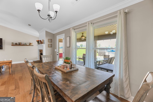 75 Flagstone Dr, Newnan, GA 30263 - dining room with light wood-style flooring, ornamental molding, a chandelier, and a fireplace