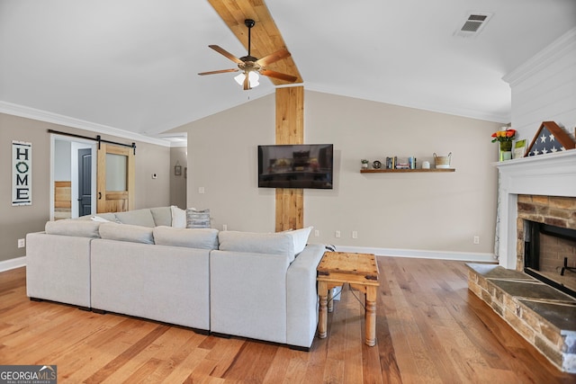 75 Flagstone Dr, Newnan, GA 30263 - living area featuring a ceiling fan, wood finished floors, a barn door, ornamental molding, and a fireplace