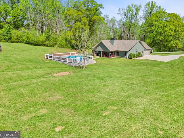 75 Flagstone Dr, Newnan, GA 30263 - view of green lawn with driveway, a garage, and view of scattered trees