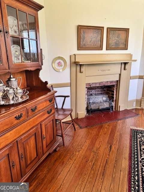 sitting room featuring dark wood-style flooring, baseboards, and a fireplace
