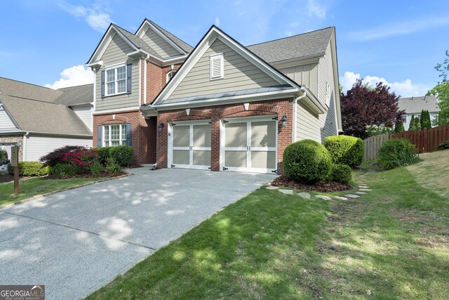 view of front of property featuring driveway, fence, brick siding, a garage, and a front yard