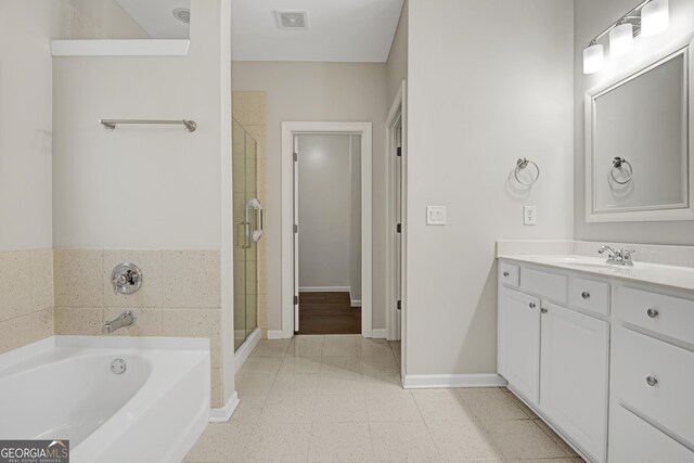 full bathroom featuring a stall shower, a bath, vanity, baseboards, and visible vents