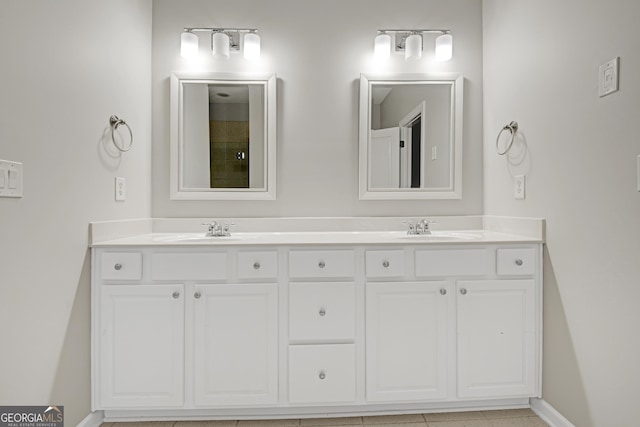 full bath featuring double vanity, baseboards, and a sink