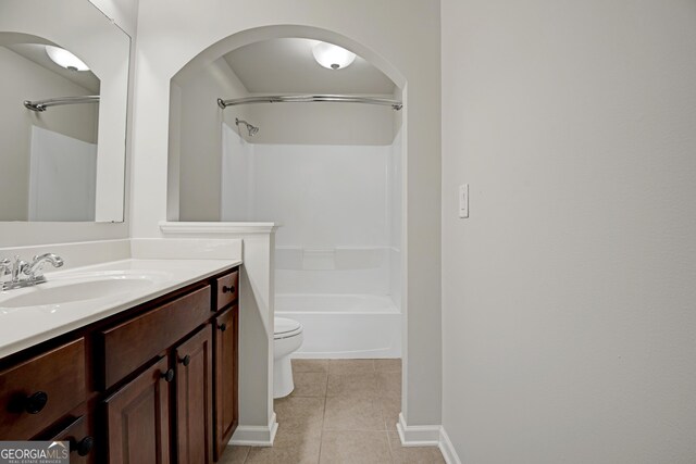 bathroom with toilet, shower / bathing tub combination, vanity, baseboards, and tile patterned flooring