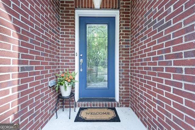 property entrance featuring brick siding
