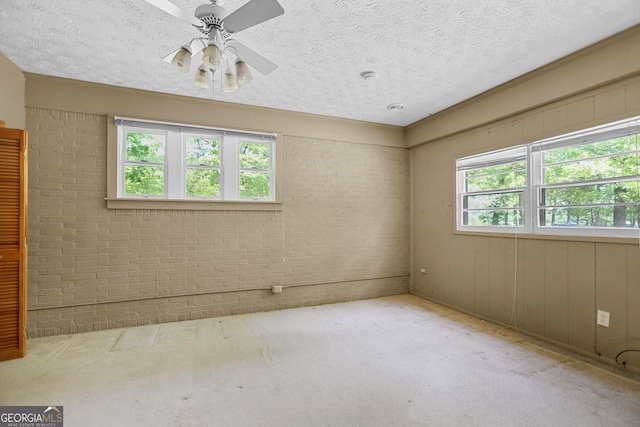 482 E Lake Rd, Mcdonough, GA 30252 - carpeted spare room with brick wall, a ceiling fan, and a textured ceiling