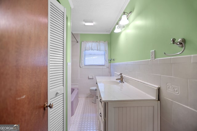 482 E Lake Rd, Mcdonough, GA 30252 - bathroom featuring a textured ceiling, vanity, bathtub / shower combination, tile walls, and toilet