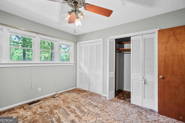482 E Lake Rd, Mcdonough, GA 30252 - unfurnished bedroom featuring a ceiling fan, a textured ceiling, multiple closets, carpet floors, and baseboards