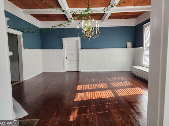 unfurnished dining area featuring wainscoting, visible vents, a chandelier, and beamed ceiling