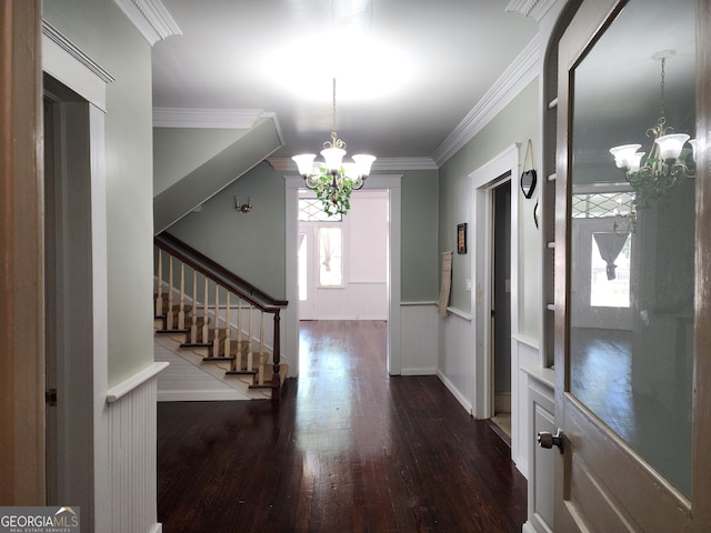 entryway featuring stairs, wood finished floors, a notable chandelier, and ornamental molding