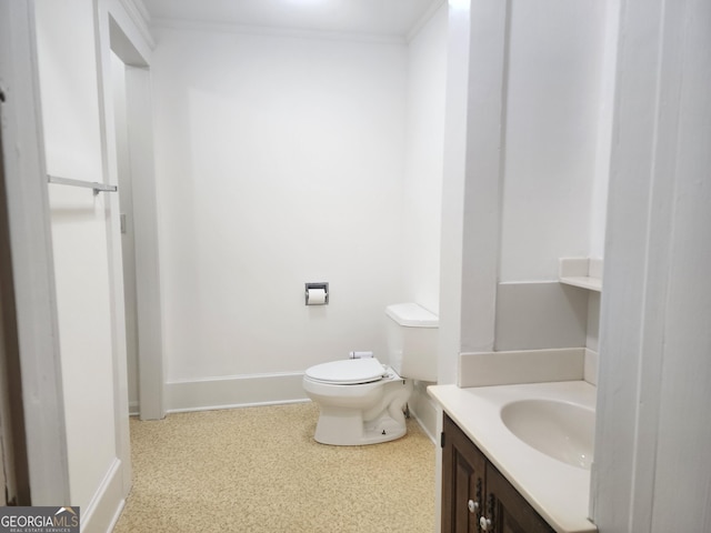 bathroom with baseboards, toilet, and vanity