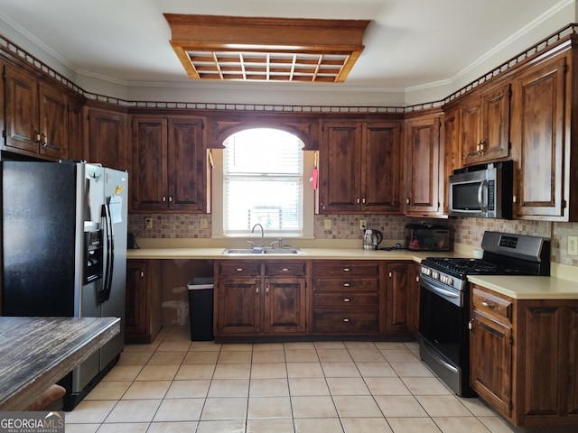 kitchen featuring decorative backsplash, light countertops, a sink, and appliances with stainless steel finishes