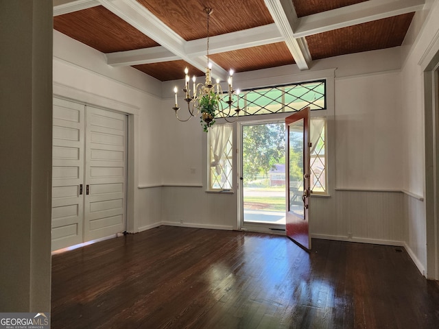 unfurnished dining area with beamed ceiling, an inviting chandelier, coffered ceiling, and wood-type flooring