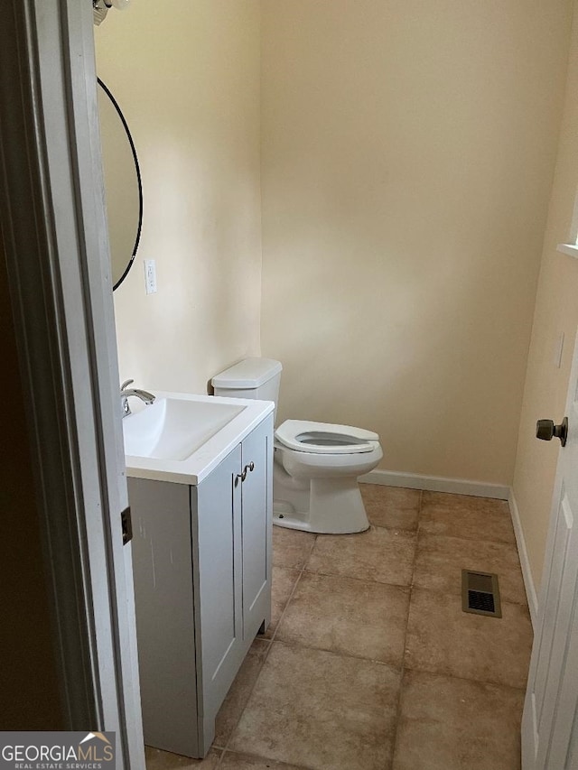 bathroom with visible vents, baseboards, toilet, vanity, and tile patterned floors