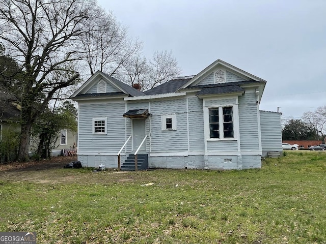 rear view of house featuring entry steps, crawl space, and a lawn
