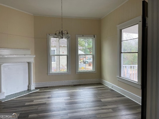 unfurnished dining area with ornamental molding, plenty of natural light, a notable chandelier, and wood finished floors