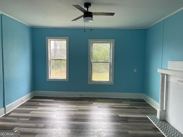 interior space with baseboards, crown molding, a ceiling fan, and wood finished floors