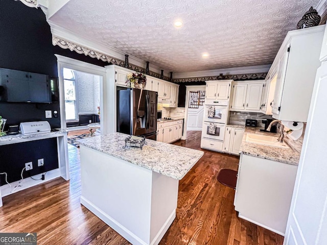 2319 Lochinver Ln SW, Conyers, GA 30094 - kitchen with black appliances, a sink, white cabinets, light stone counters, and crown molding