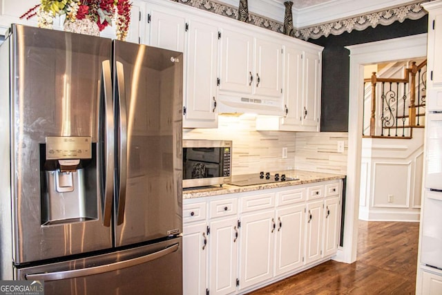 2319 Lochinver Ln SW, Conyers, GA 30094 - kitchen with appliances with stainless steel finishes, under cabinet range hood, white cabinetry, tasteful backsplash, and dark wood-style floors
