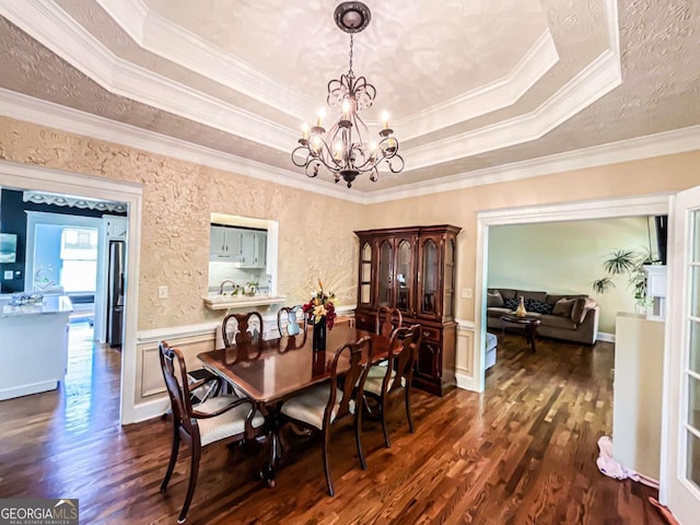 2319 Lochinver Ln SW, Conyers, GA 30094 - dining space with a tray ceiling, crown molding, dark wood finished floors, a chandelier, and wainscoting