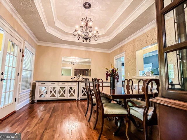 2319 Lochinver Ln SW, Conyers, GA 30094 - dining area with a chandelier, a tray ceiling, healthy amount of natural light, dark wood-style flooring, and ornamental molding
