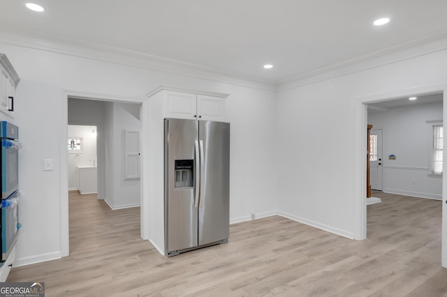 kitchen with crown molding, light wood-type flooring, white cabinets, appliances with stainless steel finishes, and baseboards