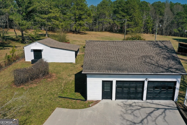 detached garage with a view of trees