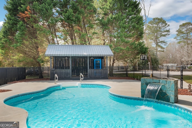 view of swimming pool featuring an exterior structure, a patio area, fence, an outdoor structure, and a fenced in pool