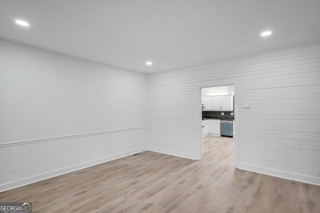 empty room with light wood-type flooring, baseboards, and recessed lighting